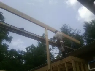 Carpenter setting a ridge beam over a new addition frame — Ice Dam Removal by Roofing Brothers in Chatfield