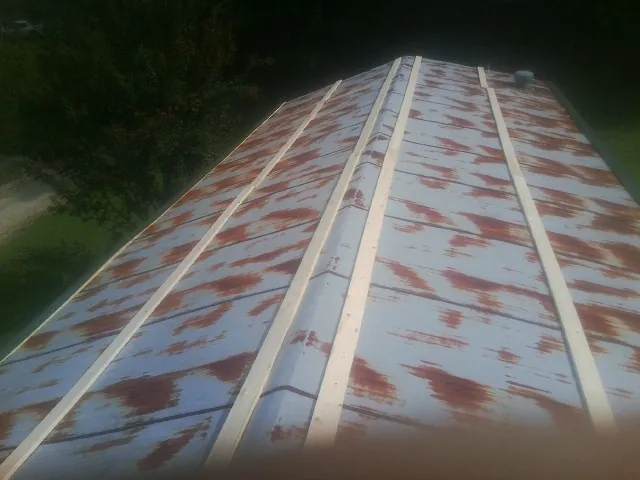 Rusted metal roof panels with new wood purlins before replacement — Storm Damage Roof Repair in Chatfield by Roofing Brothers