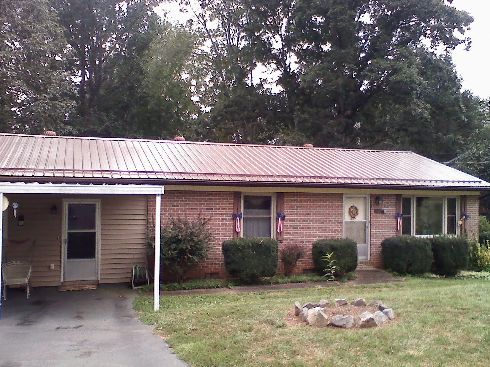 Bronze metal roof and carport on a brick ranch home — Roof Repair work by our crew in Chatfield